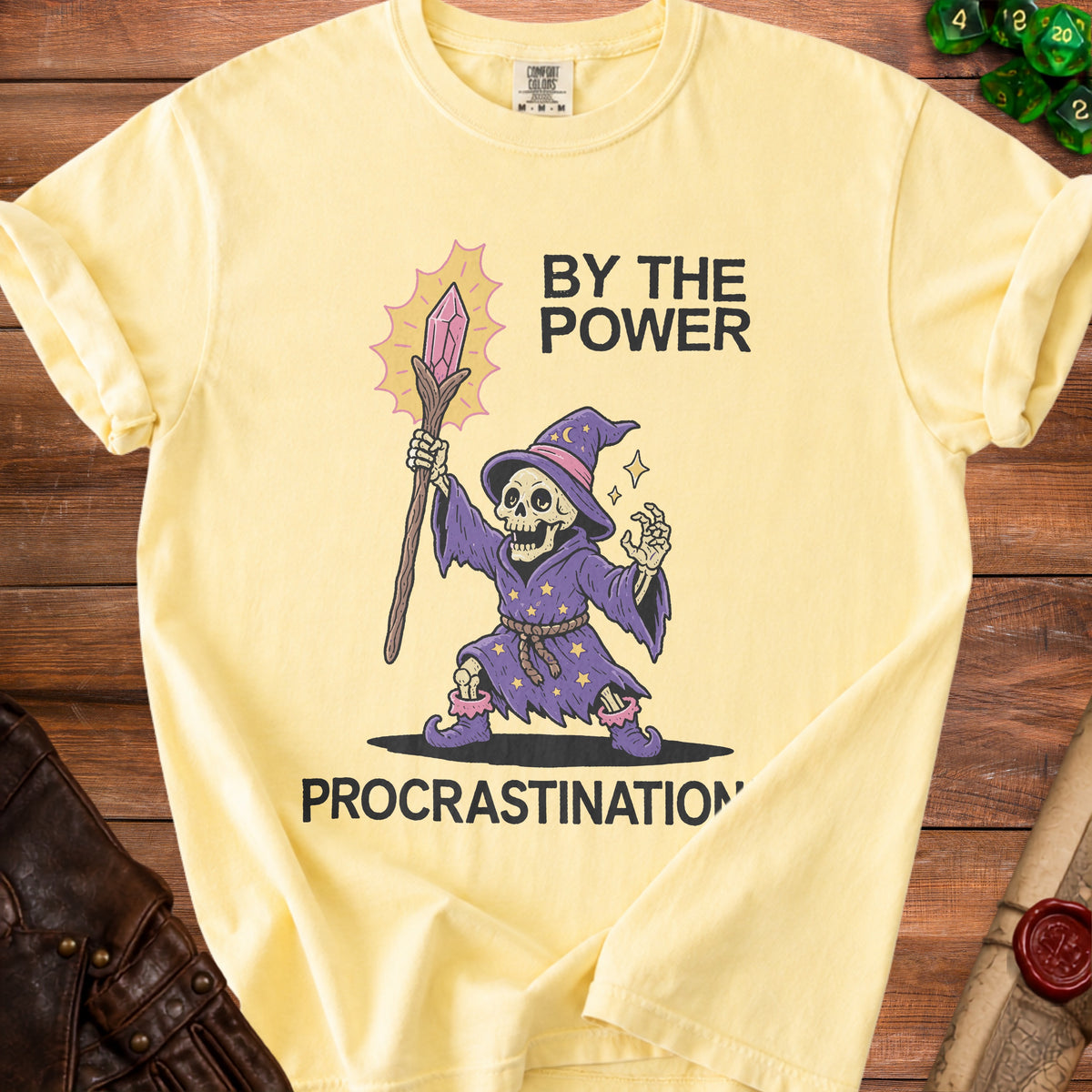 Yellow t-shirt with wizard skeleton graphic and text "BY THE POWER PROCRASTINATION"