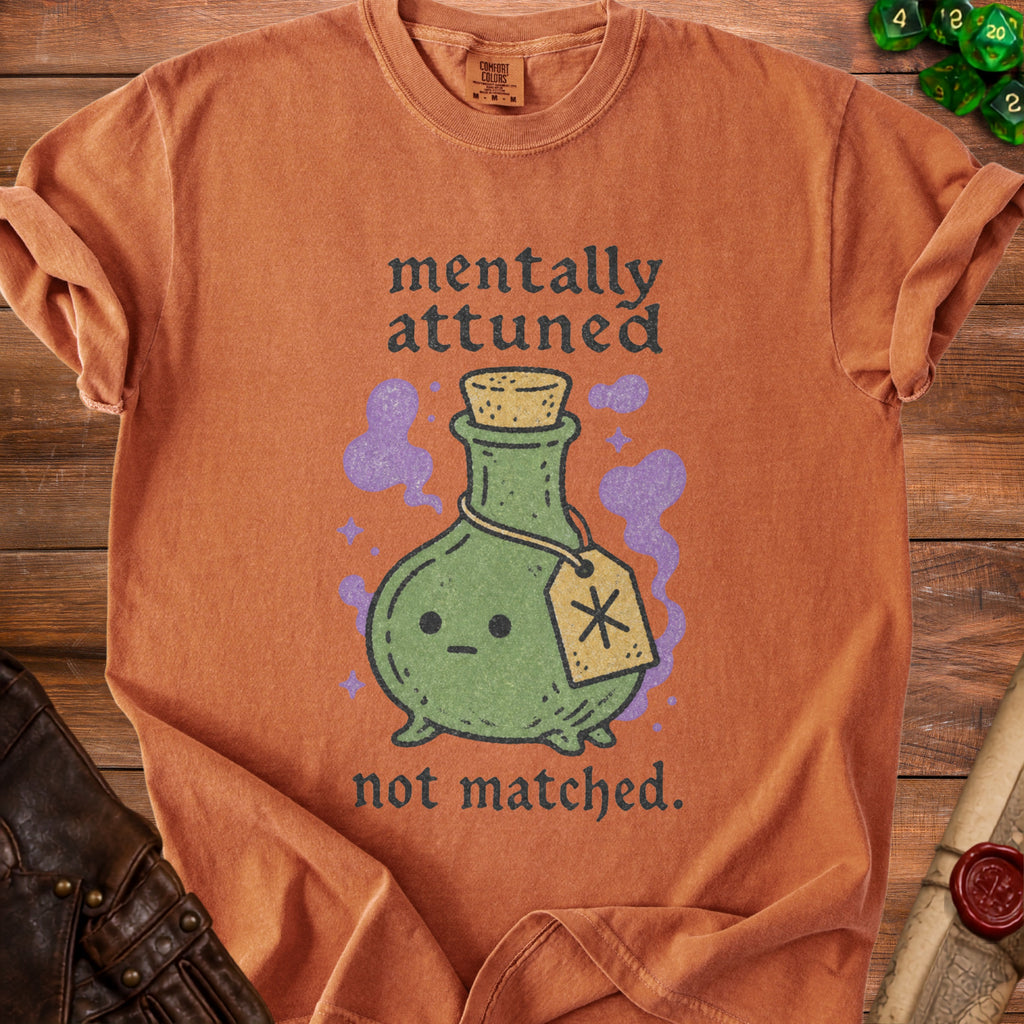 Orange t-shirt with cartoon potion bottle and text "mentally attuned not matched."