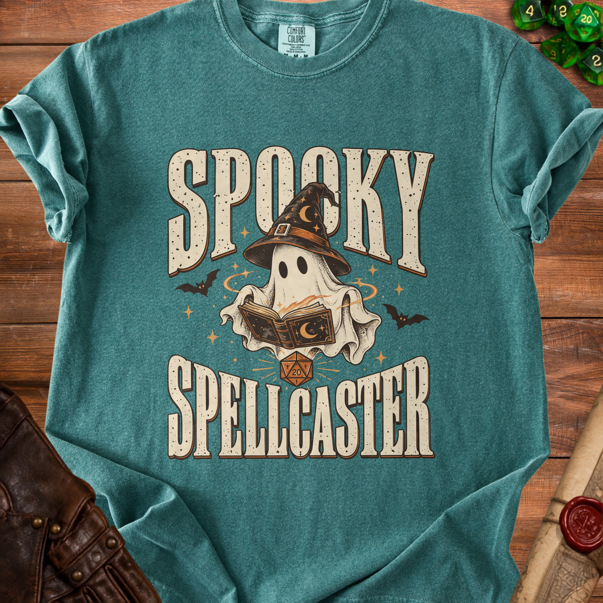 Teal t-shirt with "Spooky Spellcaster" text and a ghost wearing a witch hat reading a book.