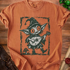 Goblin playing a lute on an orange shirt with a distressed print.