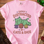 Pink t-shirt with green cat and text "Easily Distracted by Cats & Dice" and dice.