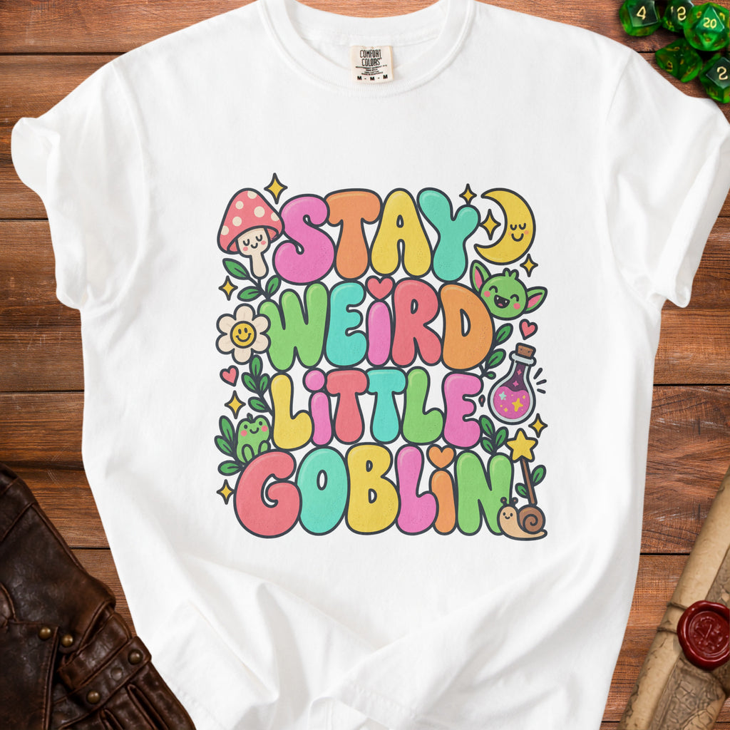White t-shirt with "Stay Weird Little Goblin" text, mushrooms, goblins, and stars.