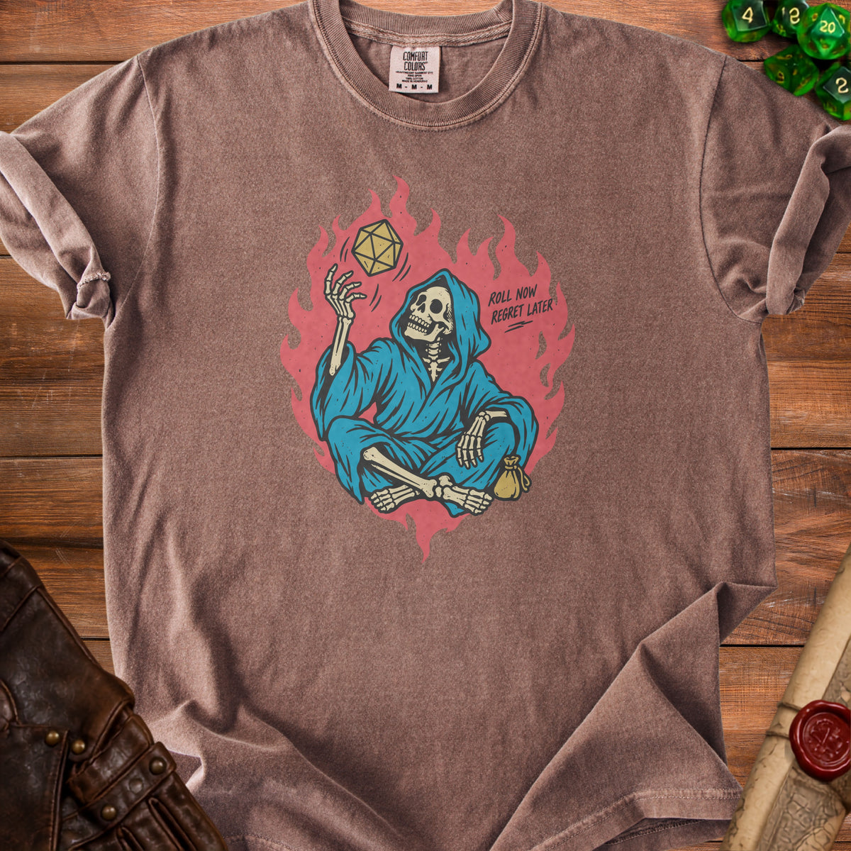 T-shirt with skeleton character juggling a D20 dice and text "ROLL NOW REGRET LATER".