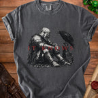 Dark t-shirt with a graphic of a knight sitting next to a raven, text "IT KNOWS".