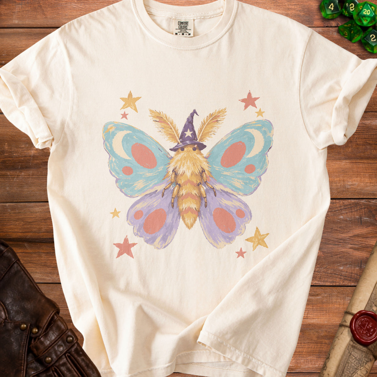 Cream t-shirt with a whimsical moth wearing a wizard hat and surrounded by stars.