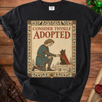 Knight kneels offering cape to black cat with text "Consider Thyself Adopted".