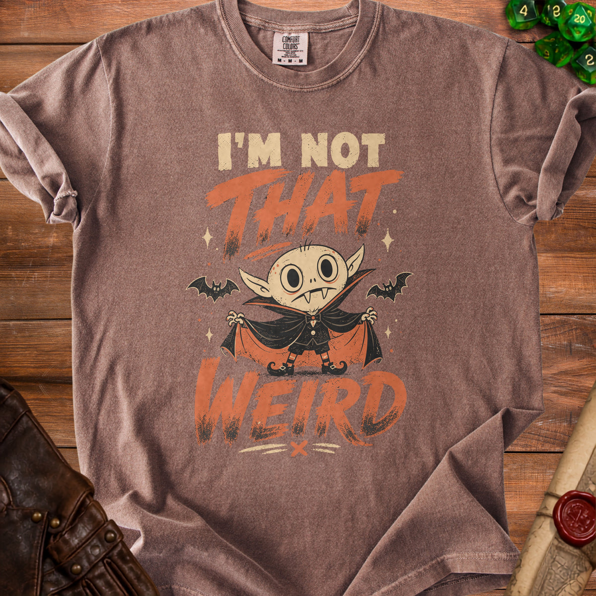 Brown t-shirt with a cartoon vampire graphic and "I'm Not That Weird" text.
