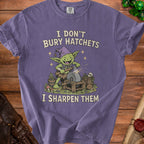Purple t-shirt with goblin sharpening an axe graphic and text "I DON'T BURY HATCHETS I SHARPEN THEM".