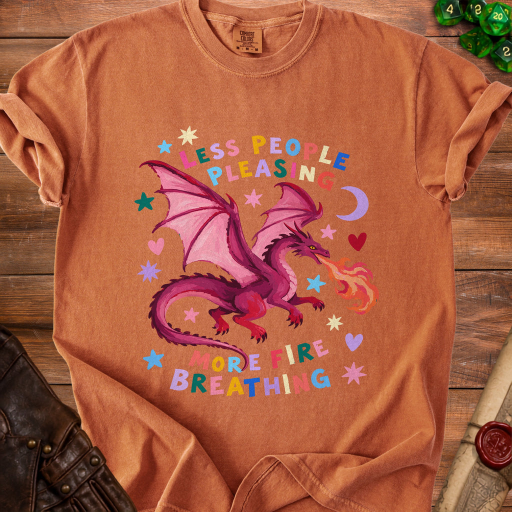 Orange t-shirt with a purple dragon breathing fire and text "Less People Pleasing, More Fire Breathing."
