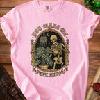 Pink t-shirt with a skeleton watering plants, text "YOU MAKE ME FEEL ALIVE".