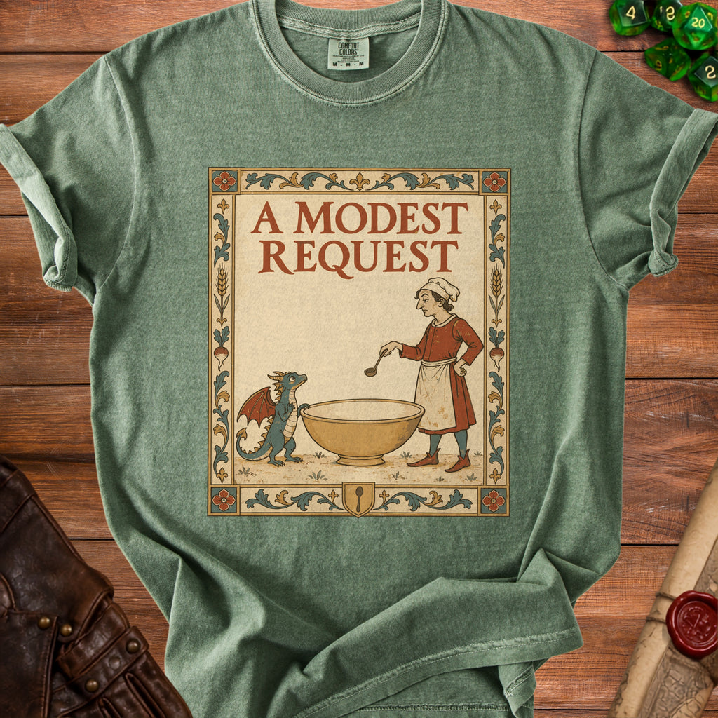 Green t-shirt featuring a medieval-style illustration of a cook and dragon beside a bowl, with text "A Modest Request".