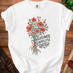 White t-shirt with red wildflowers, a sword, keys, and the text "WILDFLOWERS & WEIRD LITTLE QUESTS".