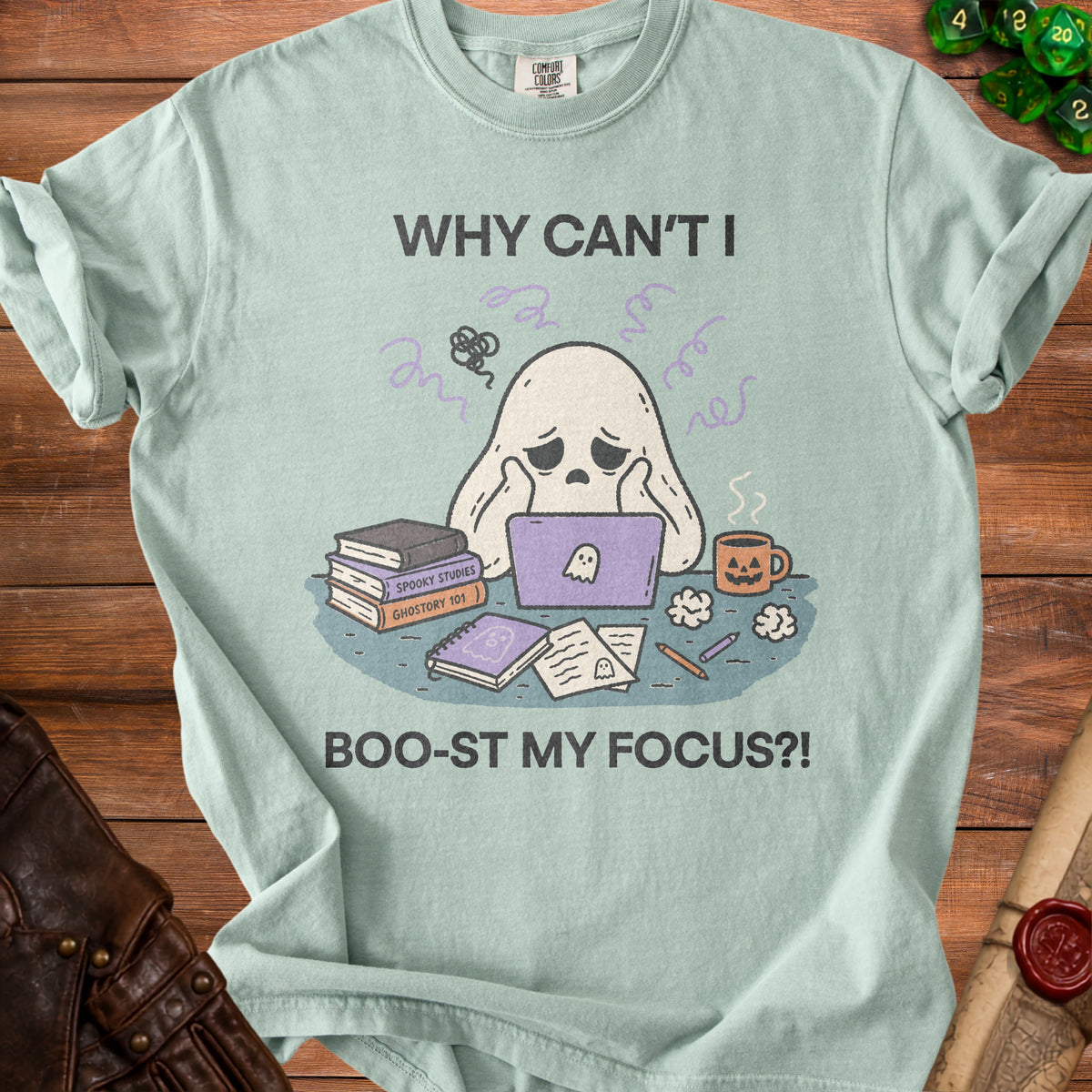 Light blue t-shirt graphic with a ghost on a laptop, books, and text "Why Can't I Boo-st My Focus?!".