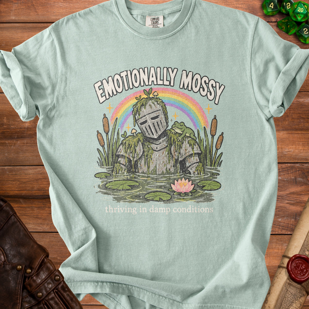 Light green t-shirt with "Emotionally Mossy" and frog on armored knight illustration.