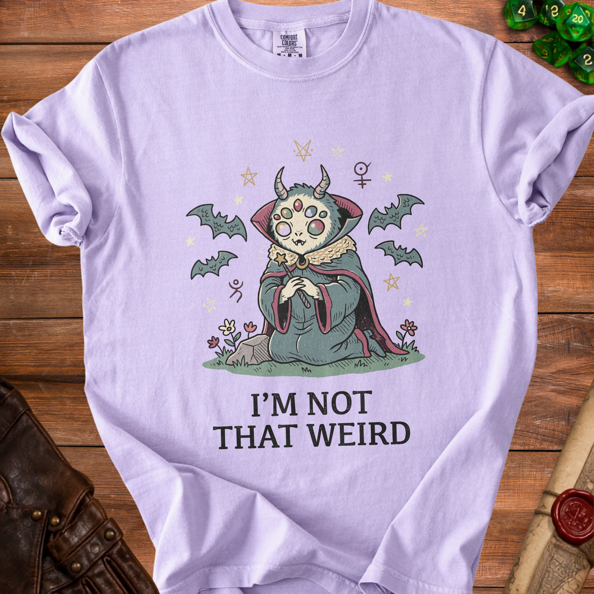 Lavender t-shirt with a creature, bats, stars, and the text "I'M NOT THAT WEIRD".