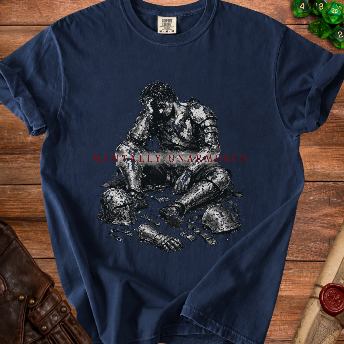 Dark blue t-shirt with an illustration of a knight sitting dejectedly amidst scattered armor pieces.