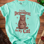 Teal t-shirt with cat and dice graphic reading "Critically Dependent On My Cat".