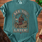 Grim reaper in a boat with pumpkin and lantern, text "See You Later".