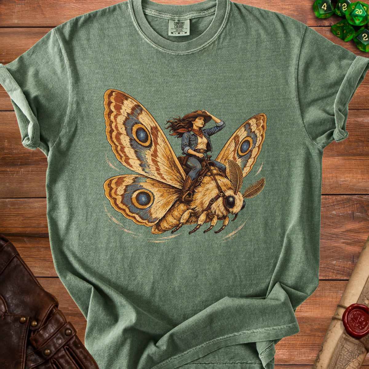 Green t-shirt featuring a woman in cowboy attire riding a moth.