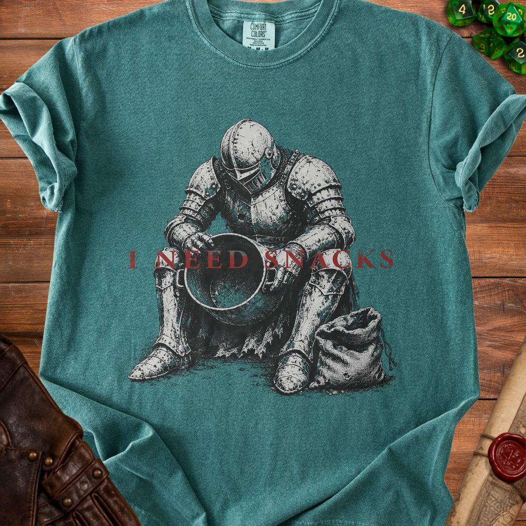 Green t-shirt with distressed knight art and "I NEED SNACKS" text.