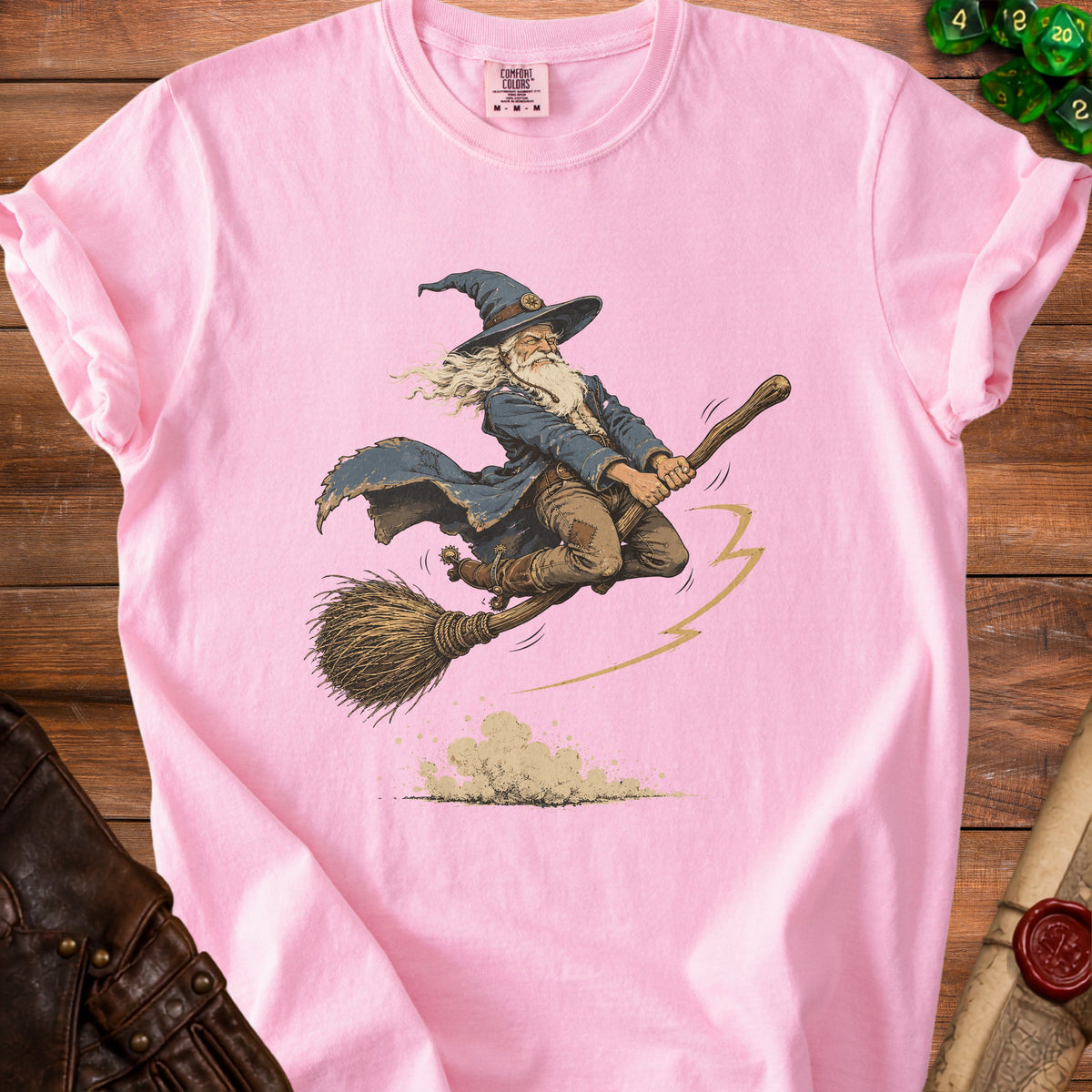 Pink t-shirt with wizard on a broomstick graphic and comfort colors tag.