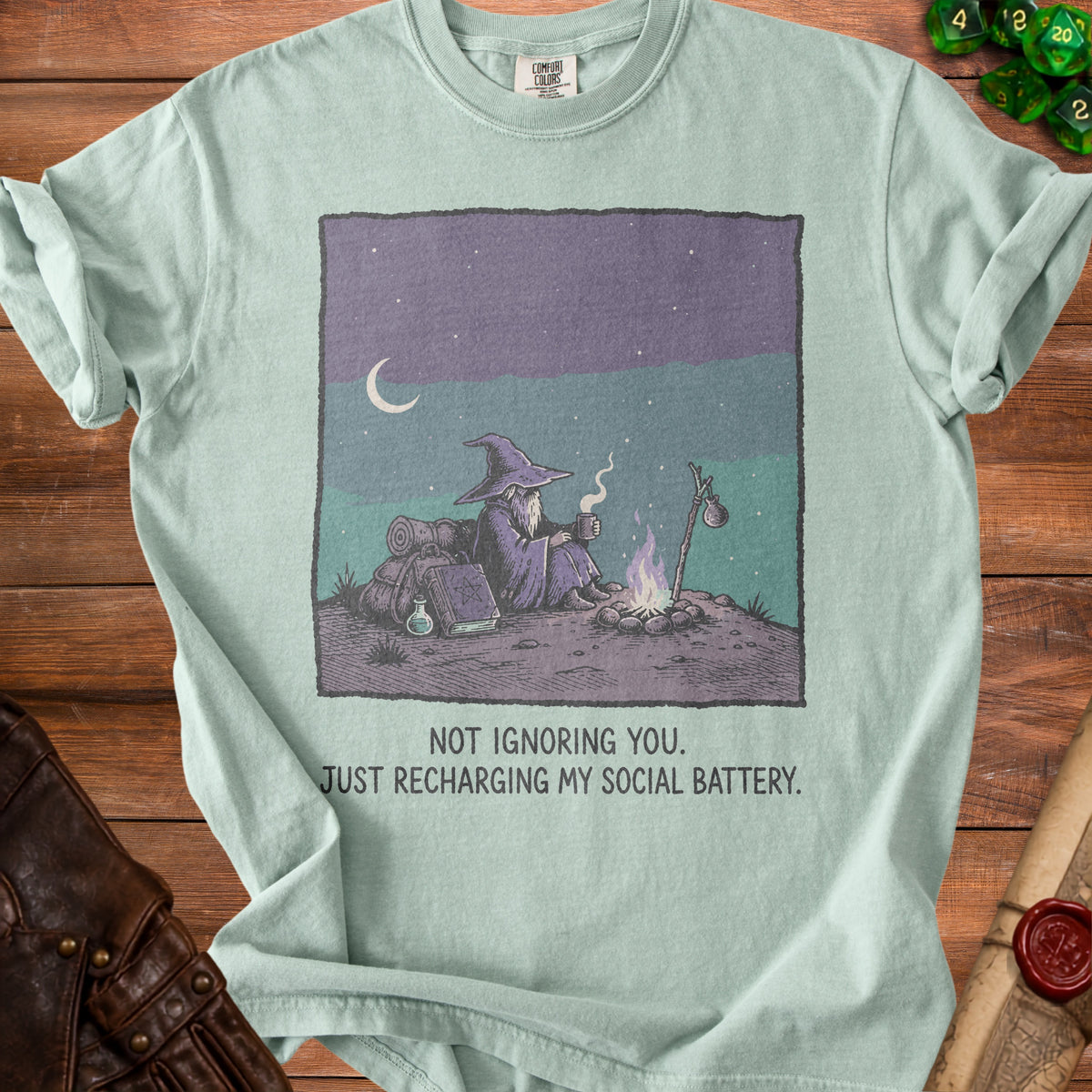 Wizard sitting by a campfire with text "Not Ignoring You. Just Recharging My Social Battery."