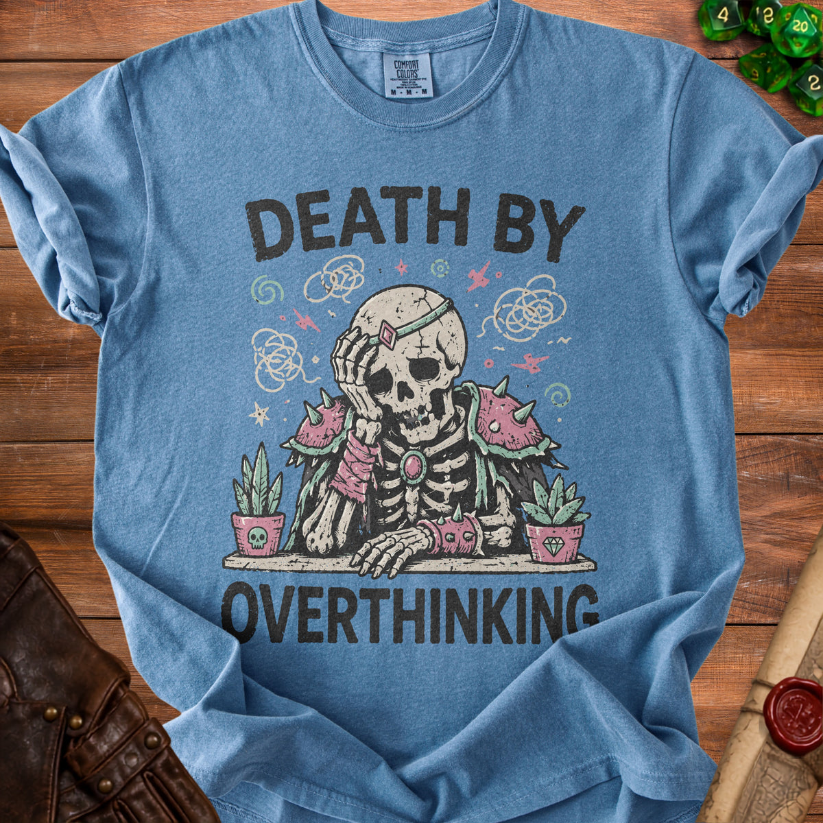 Blue t-shirt with "Death by Overthinking" graphic of a skeleton and plants.