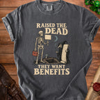 Dark gray t-shirt with skeleton and grim reaper graphic, "Raised the Dead They Want Benefits" text.