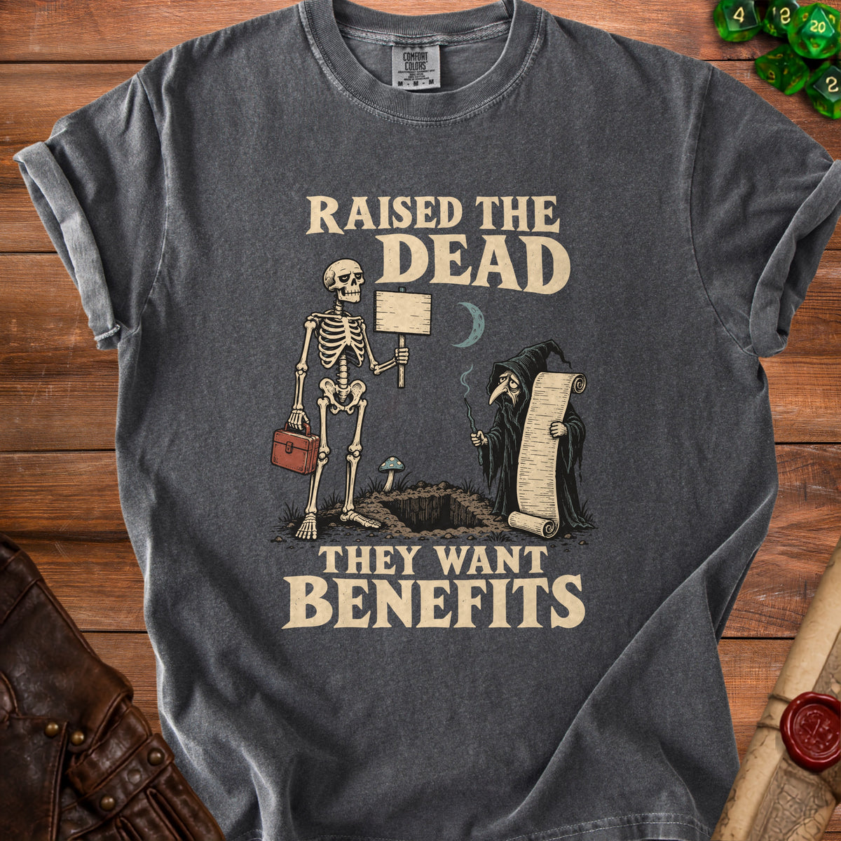Dark gray t-shirt with skeleton and grim reaper graphic, "Raised the Dead They Want Benefits" text.