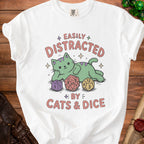 White t-shirt with green cat and dice graphic saying "Easily Distracted By Cats & Dice".
