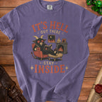 Purple t-shirt graphic: demon reading by fireplace, "It's Hell Out There, Stay Inside".