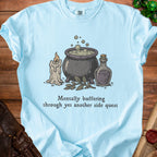 Light blue t-shirt with cauldron, candle, potion, and text.