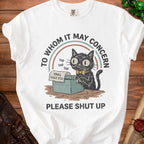 White t-shirt with black cat at typewriter, "To Whom It May Concern" and "Please Shut Up."