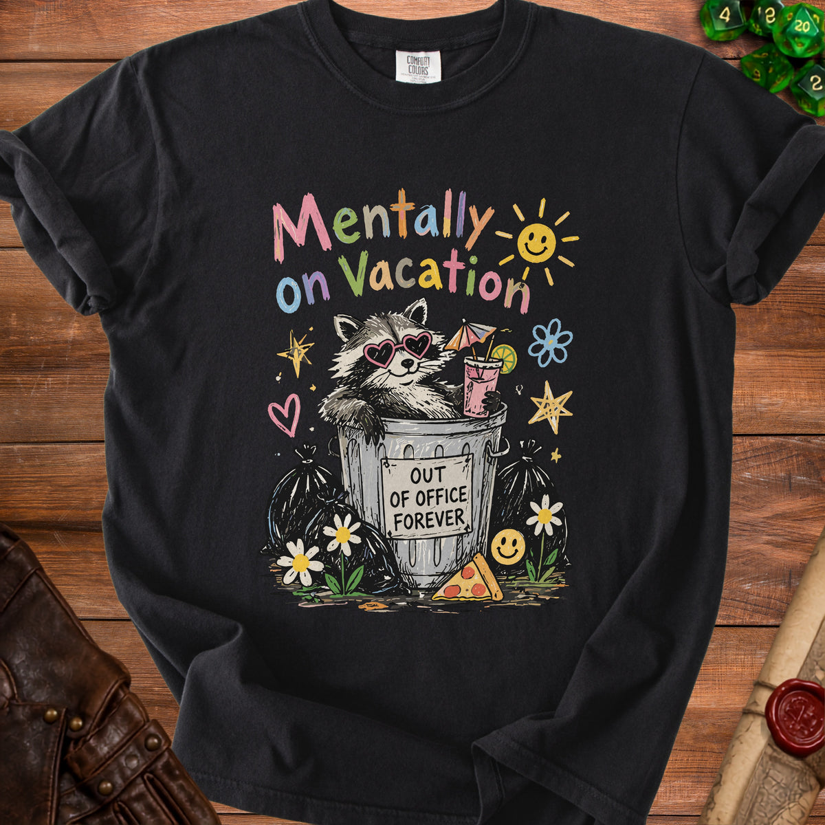 Black t-shirt with "Mentally on Vacation" and raccoon in trash can graphic.