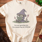 Cream t-shirt with wizard mushroom reading "How to Not Care (A Novel)" and text.