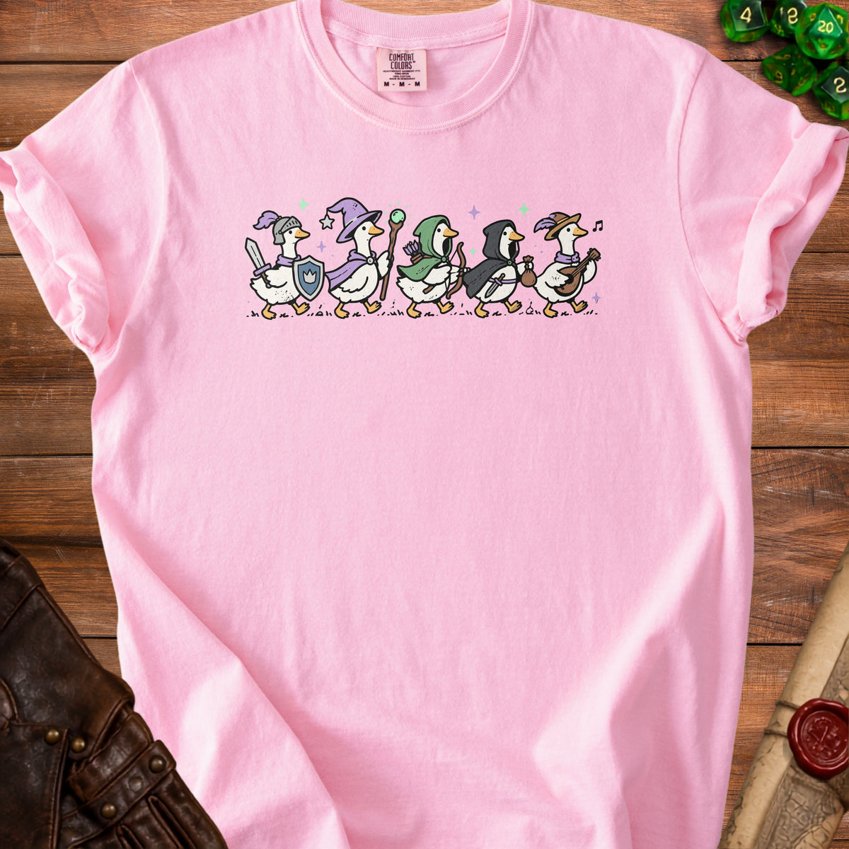 Pink t-shirt with ducks dressed as fantasy adventurers, like a knight, wizard, and archer.