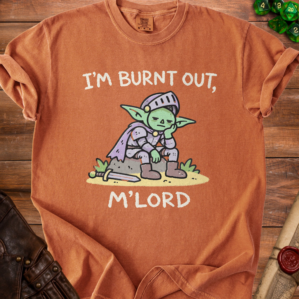 Orange t-shirt with a cartoon goblin knight sitting on rocks, saying "I'm Burnt Out, M'Lord."