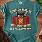 Teal t-shirt with black cat and gold dragon graphic reading "Dungeon Master, It's All Canon Now."