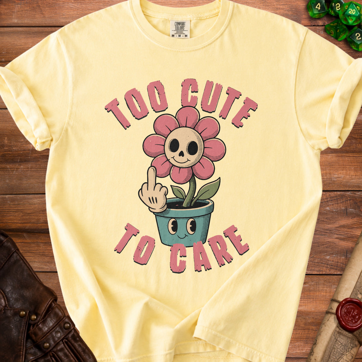Yellow t-shirt with "Too Cute To Care" text and a cartoon skull flower.