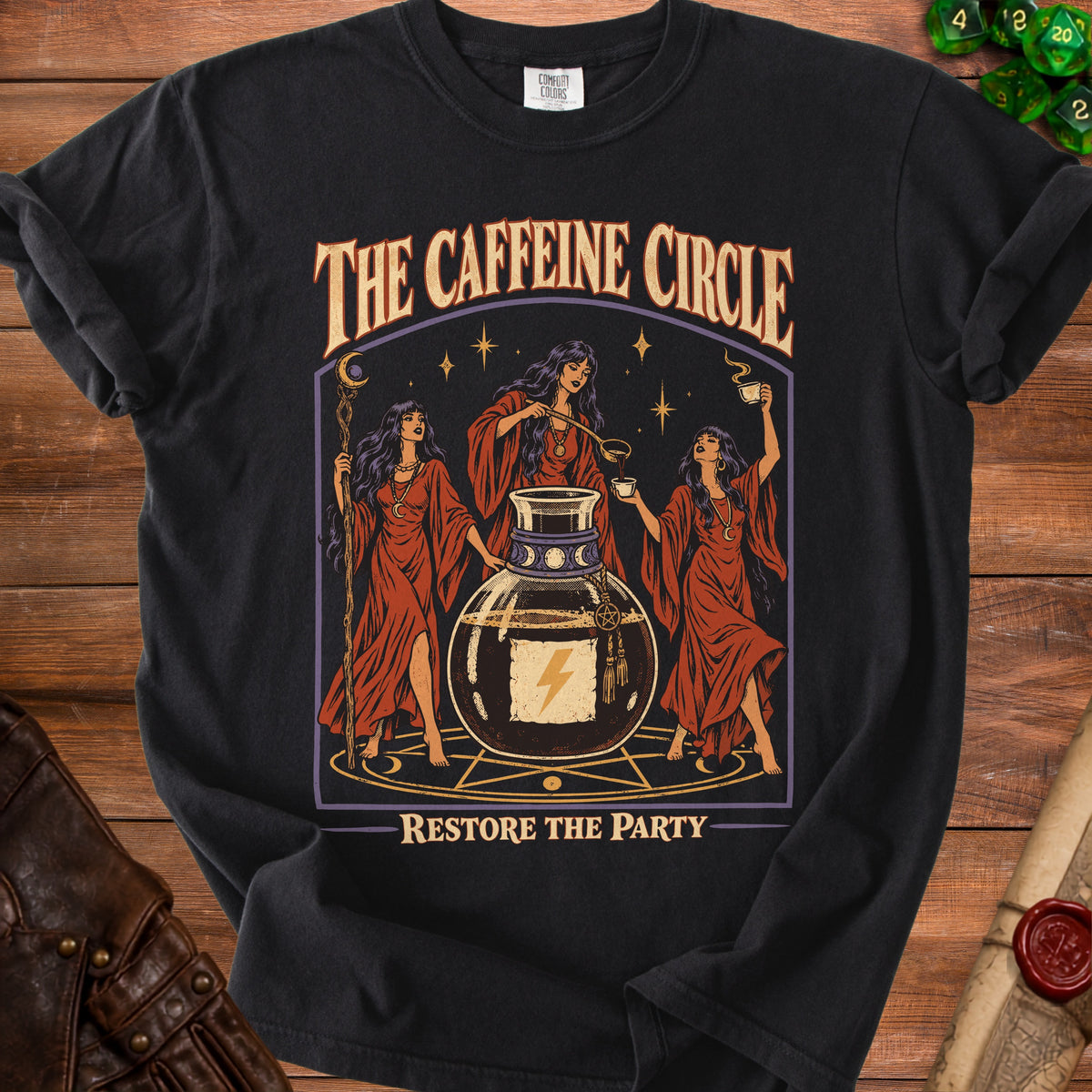 Black t-shirt with "The Caffeine Circle" and "Restore the Party" text featuring witches and a potion bottle.