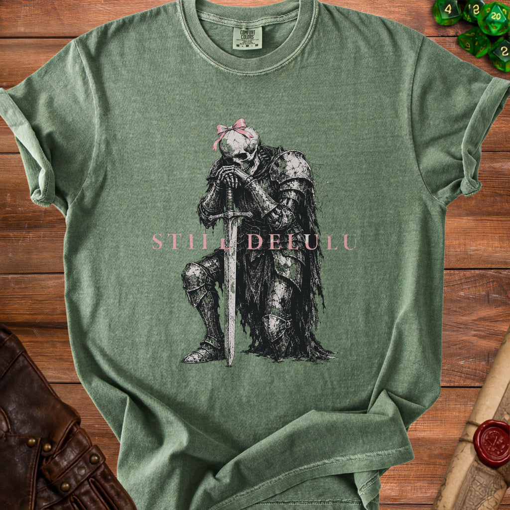 Green t-shirt with skeleton knight graphic and "STILL DELULU" text.