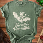 Green t-shirt with a cat riding a bat, saying "Socially Unavailable".