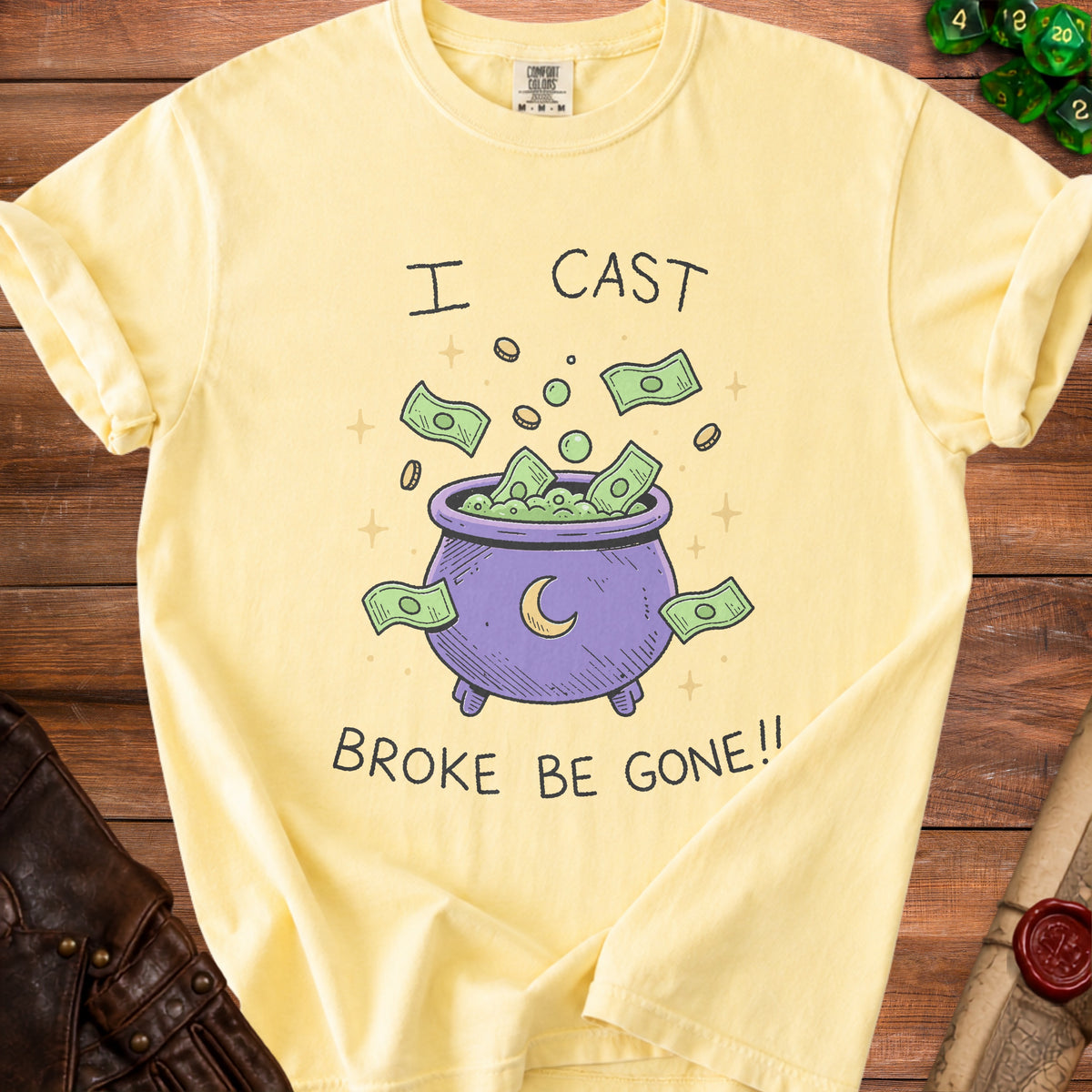 Yellow t-shirt with "I Cast Broke Be Gone!!" text and a cauldron spilling money.