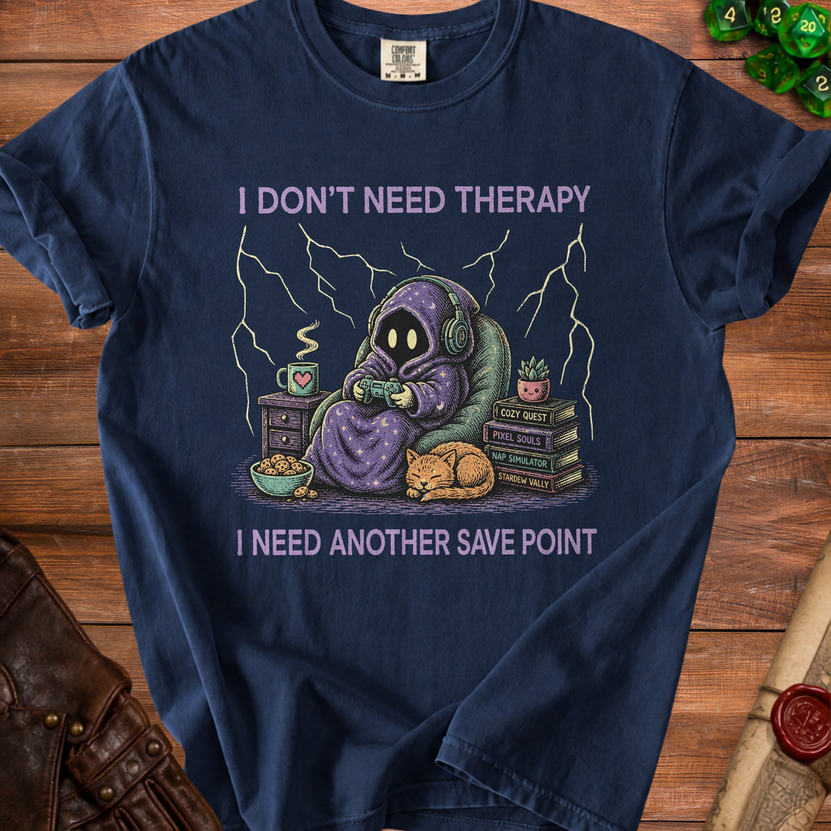 Graphic tee with hooded figure playing video games, cat, and text "I DON'T NEED THERAPY I NEED ANOTHER SAVE POINT".