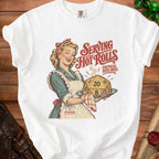 White t-shirt with a retro woman serving a D20 die that reads "SERVING HOT ROLLS".