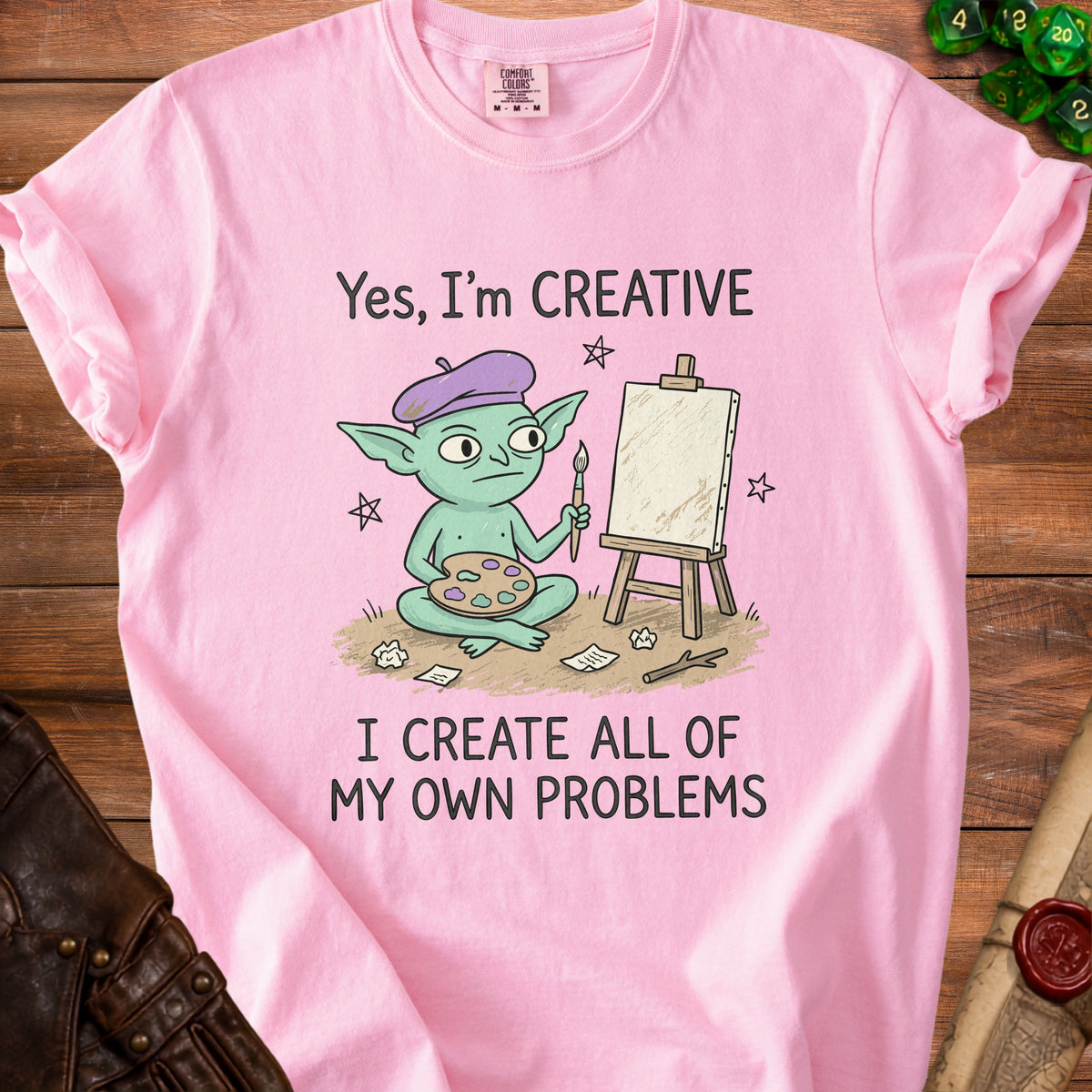 Pink t-shirt with cartoon goblin artist and text "Yes, I'm CREATIVE. I CREATE ALL OF MY OWN PROBLEMS."
