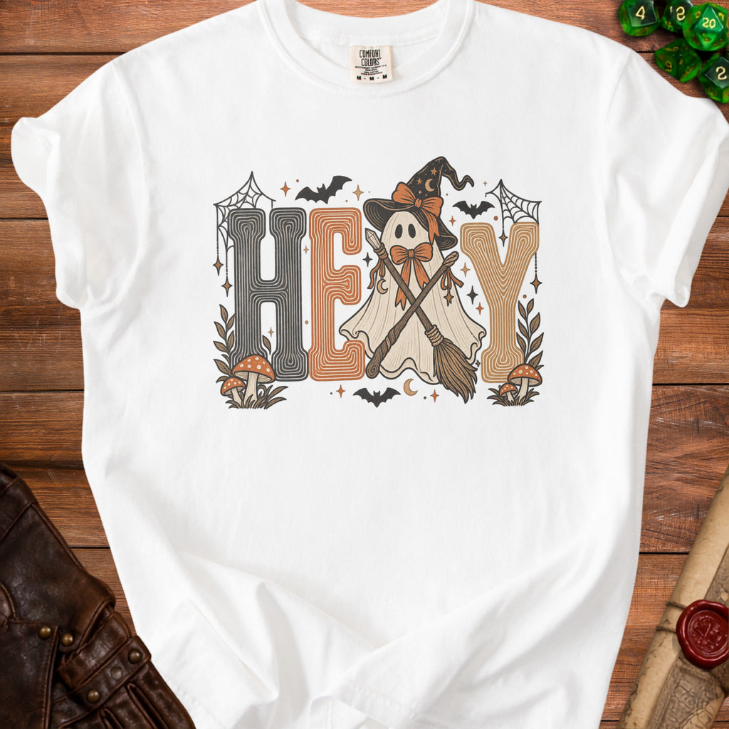 White t-shirt with "HEY" text featuring a ghost with witch hat and brooms.