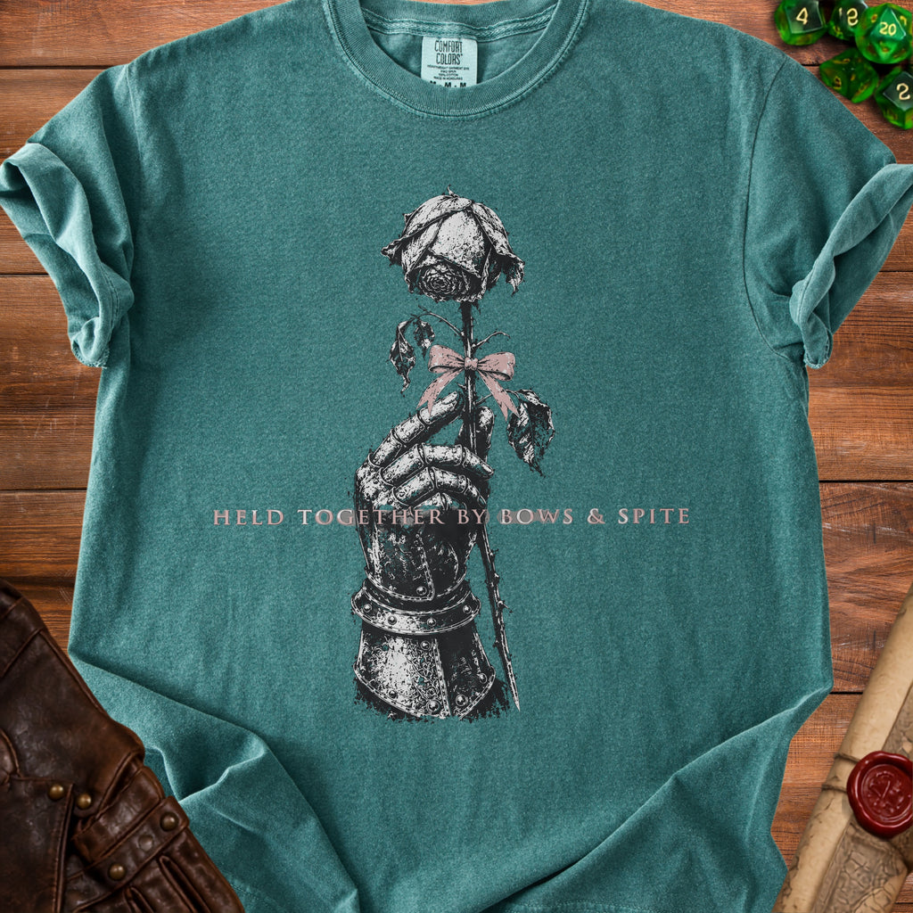 Teal t-shirt with knight's gauntlet holding a rose with text "HELD TOGETHER BY BOWS & SPITE".