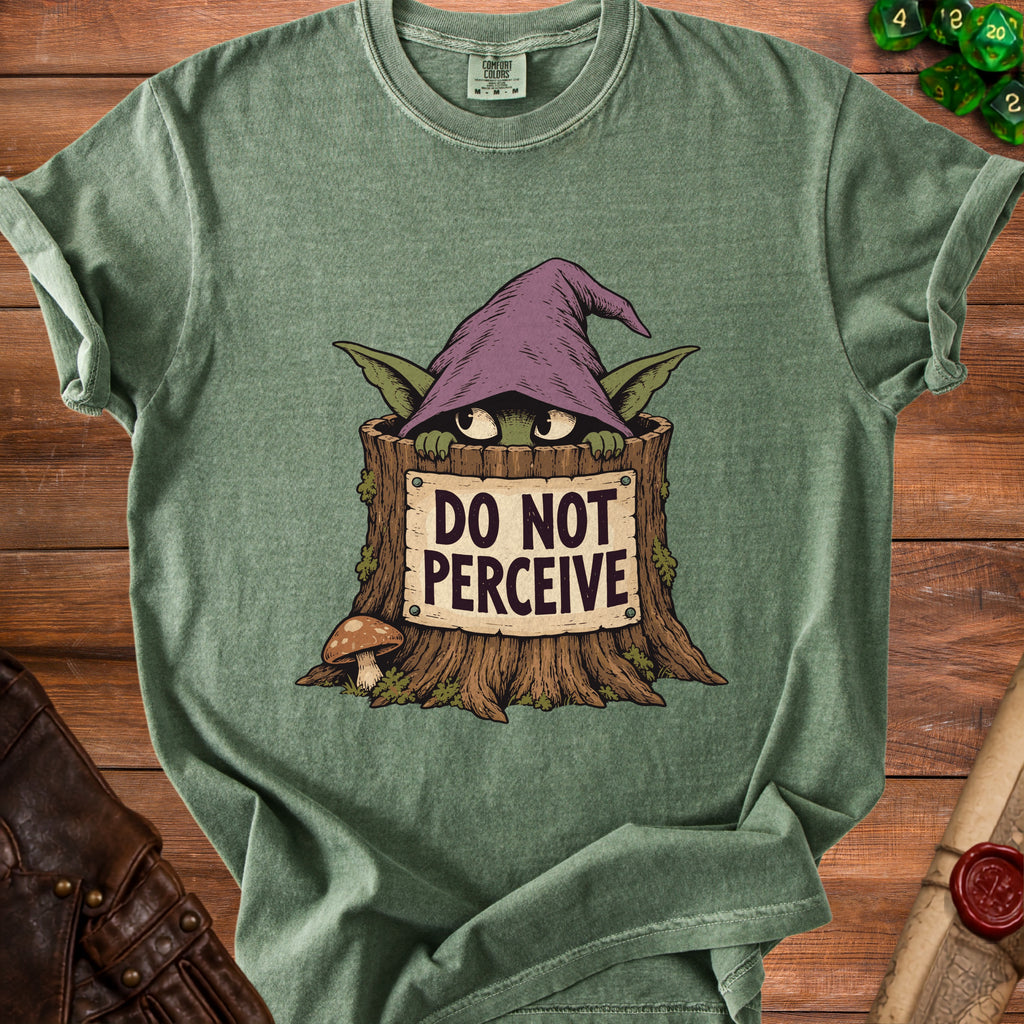 A green t-shirt featuring a graphic of a creature in a tree stump wearing a witch hat and a sign that reads DO NOT PERCEIVE.