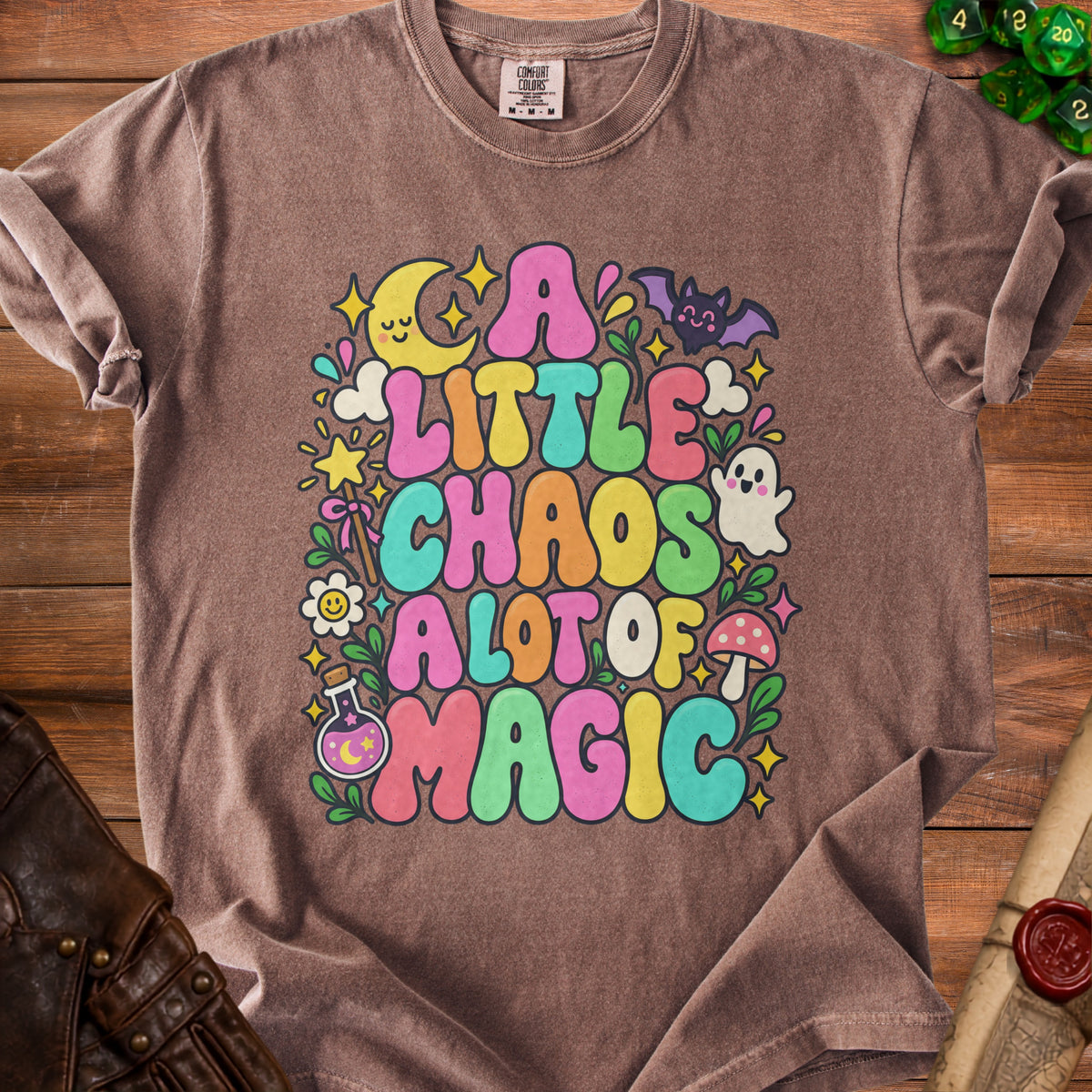 Brown t-shirt with colorful graphic reading "A Little Chaos A Lot of Magic."